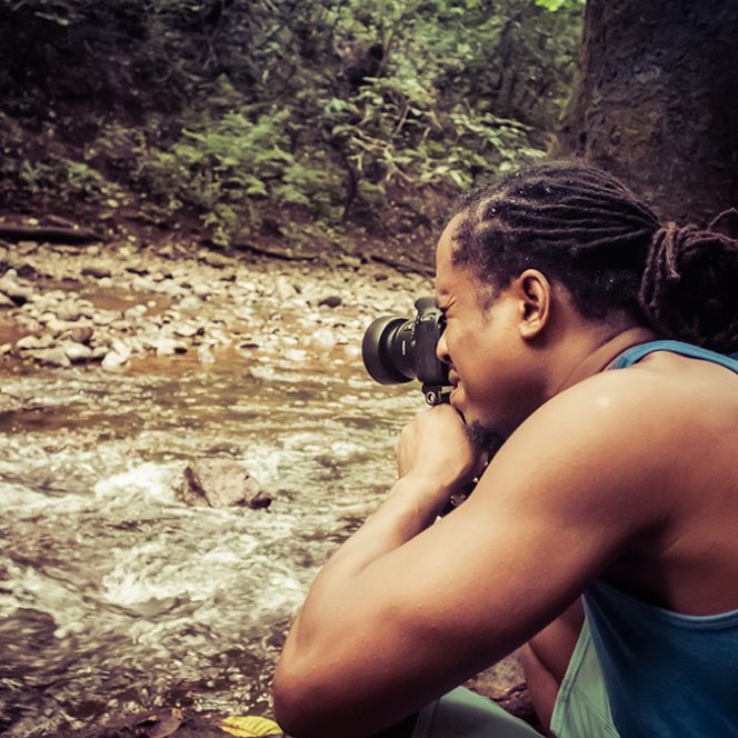 Over the shoulder photo of author crouched down while shooting a photo in Costa Rica